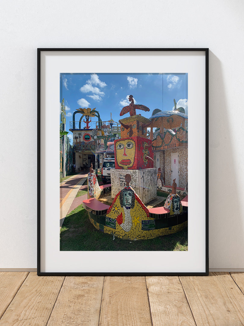 A photograph of a colorful sculpture with a face against a blue sky in Havana