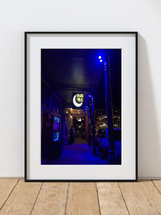 A photograph of a neon-lit alleyway at night in New Orleans.